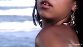 Two really attractive women engaged in intimate and intense sexual activity with a man on the beach