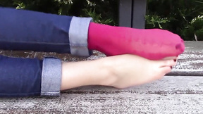 Barefoot brunette shows off her feet in public in the park