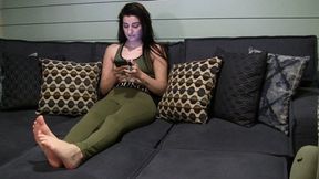 J chills on the couch with her bare feet on display
