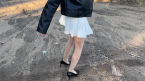 a girl in high heels went to a very muddy area where her shoes turned into pieces of mud, she trampled them into the mud and tore her stockings