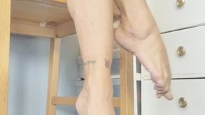 bare legs crossing in wooden chair