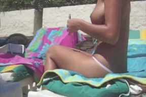 Gorgeous blonde lady is sun bathing topless at the sunny day