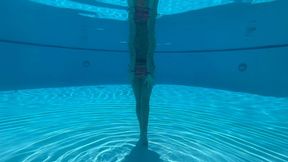 Wrist self-bondage in the resort pool in a rainbow bikini