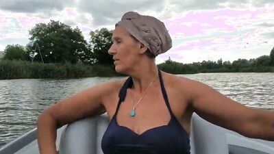 Mature lady paddles in that boat as her partner films her legs