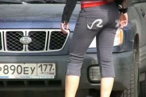 Juicy Russian brunette lady hides behind the car and pisses