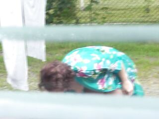 Neighbour in bathrobe out of pants and brassiere dries washing courtyard, neighbor watching out window