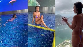 monika fox in purple bikini swims in pool & poses by window against background of city