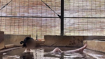 Japanese girl bathing in a mixed outdoor bath at a hot spring inn