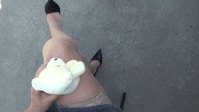 a small teddy bear sits astride my crossed legs L