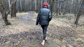 A girl in high-heeled shoes walks through the deep and sticky mud of the forest, dirtying her shoes and heels