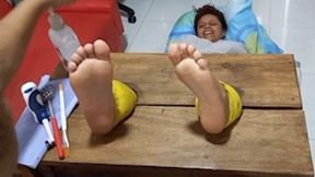 Paula tickles her soles in the vertical stocks
