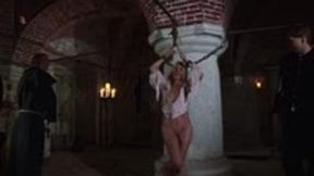 Romina, accused of witchcraft, is chained to a pillar and whipped to learn humility