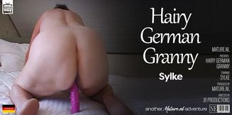 German granny Sylke plays with her hairy pussy in the shower