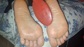 Tied and oiled soles tickled, while she can't move