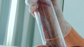 Putting on latex medical gloves while pumping a penis