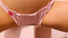 Raven-haired vixen thrusts hips against the table edge, pink lingerie a blur