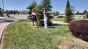 Two girls exposing their breasts to passersby on a dirty street corner