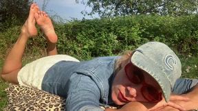 Lola rubbing her bare soles in the park
