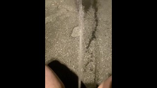 顽皮的女孩蹲在她的车道上，释放她的强力小便喷泉供公众观看