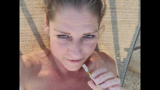 裸体熟女在泳池边抽烟和猫戏