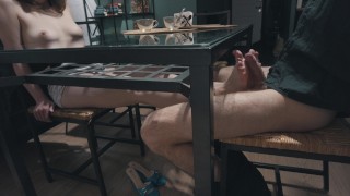 娇小的女孩用美丽的胸部在桌子下做热脚丫子。