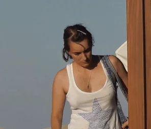 slow-mo bouncing at the beach under a braless tank-top